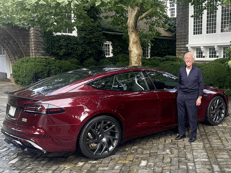 A photo of Ron Baron with his brand new, wine colored "Signature" Model S Tesla